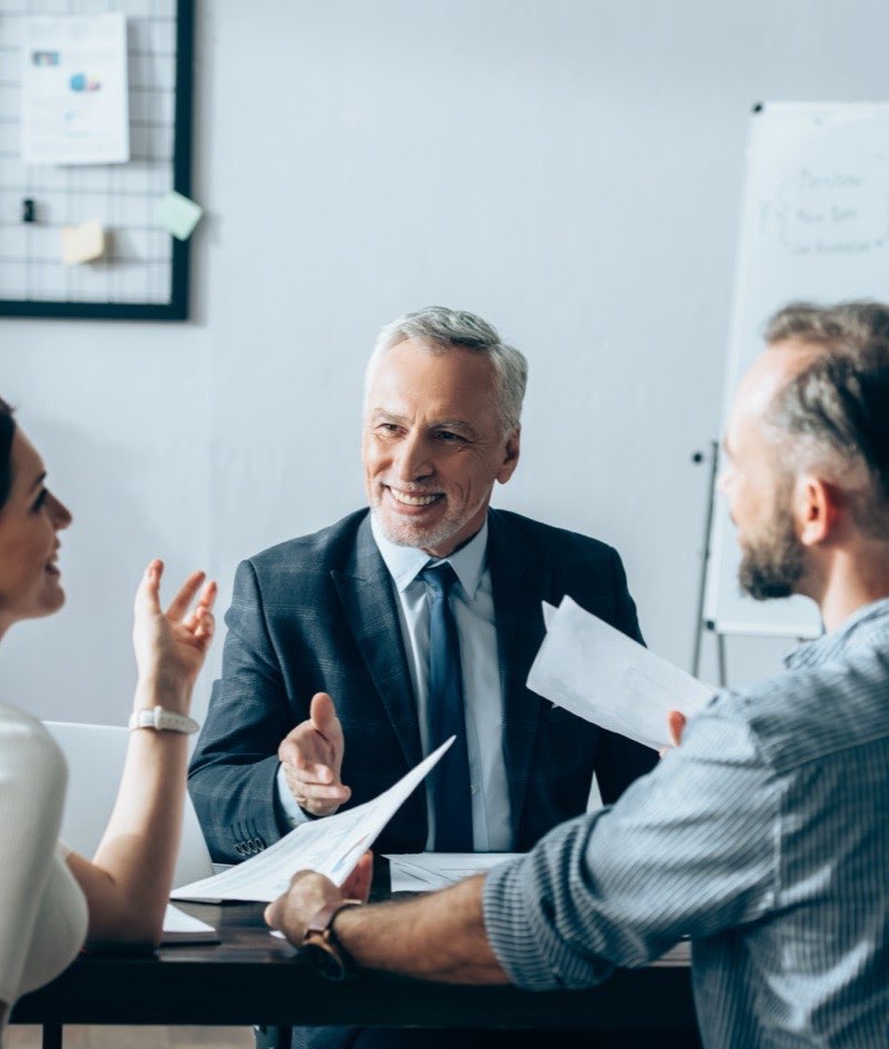 Investor im Gespräch mit zwei Gründern am Besprechungstisch